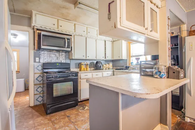a kitchen with stainless steel appliances granite countertop a stove microwave and sink