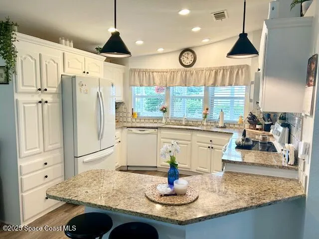 a kitchen with stainless steel appliances granite countertop a sink a stove and a refrigerator