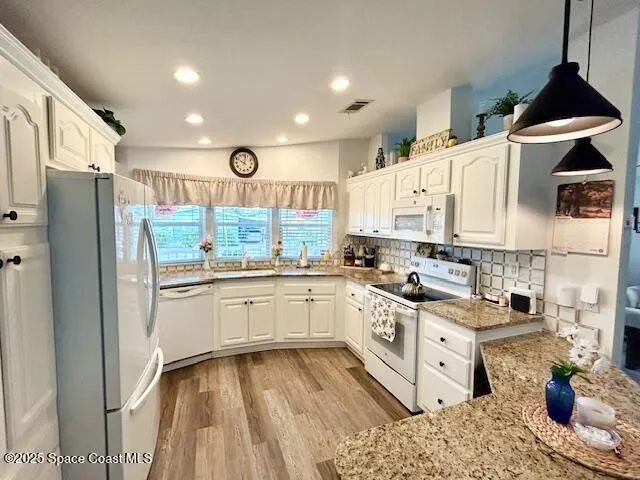a kitchen with granite countertop a sink stove and refrigerator
