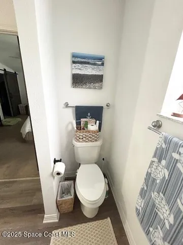 a white toilet sitting next to a sink and a mirror