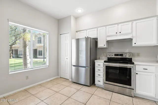 a kitchen with white cabinets stainless steel appliances and a sink