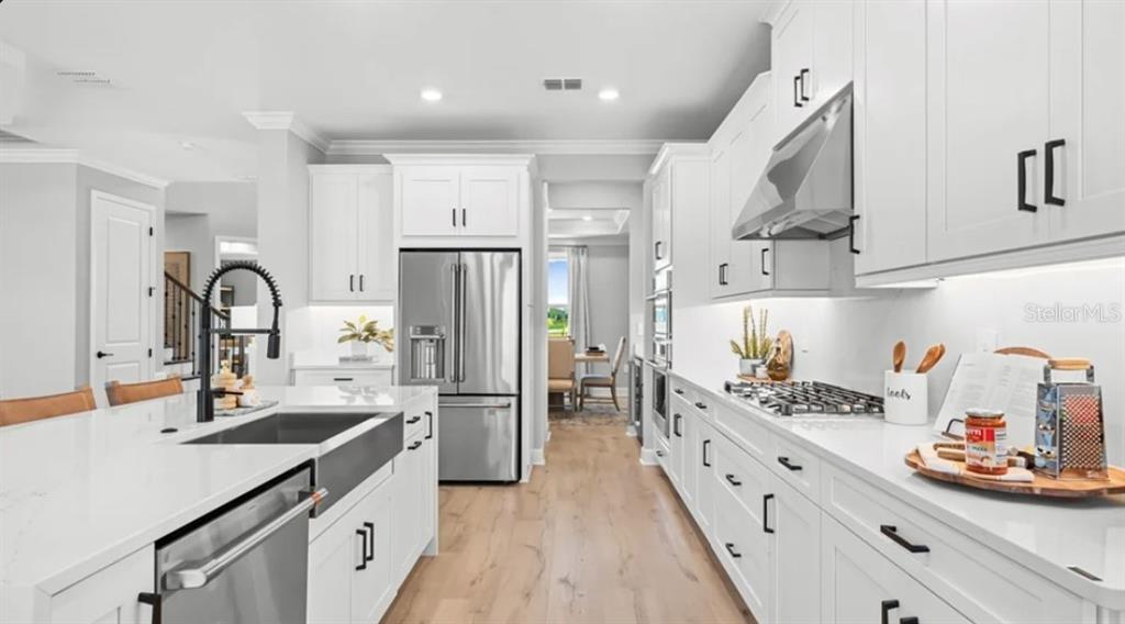 13618 Cornerstone Way Parrish, FL 34219 - Photo 2 of 27 a kitchen with refrigerator a sink and cabinets