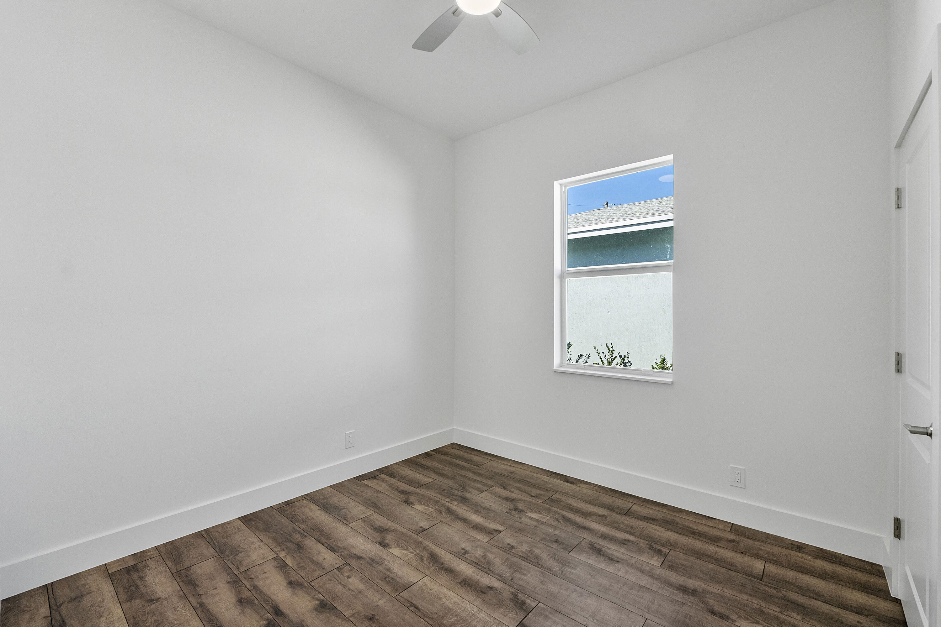 1573 West 16th Street Riviera Beach, FL 33404 - Photo 14 of 23 a view of an empty room with a window and a ceiling fan