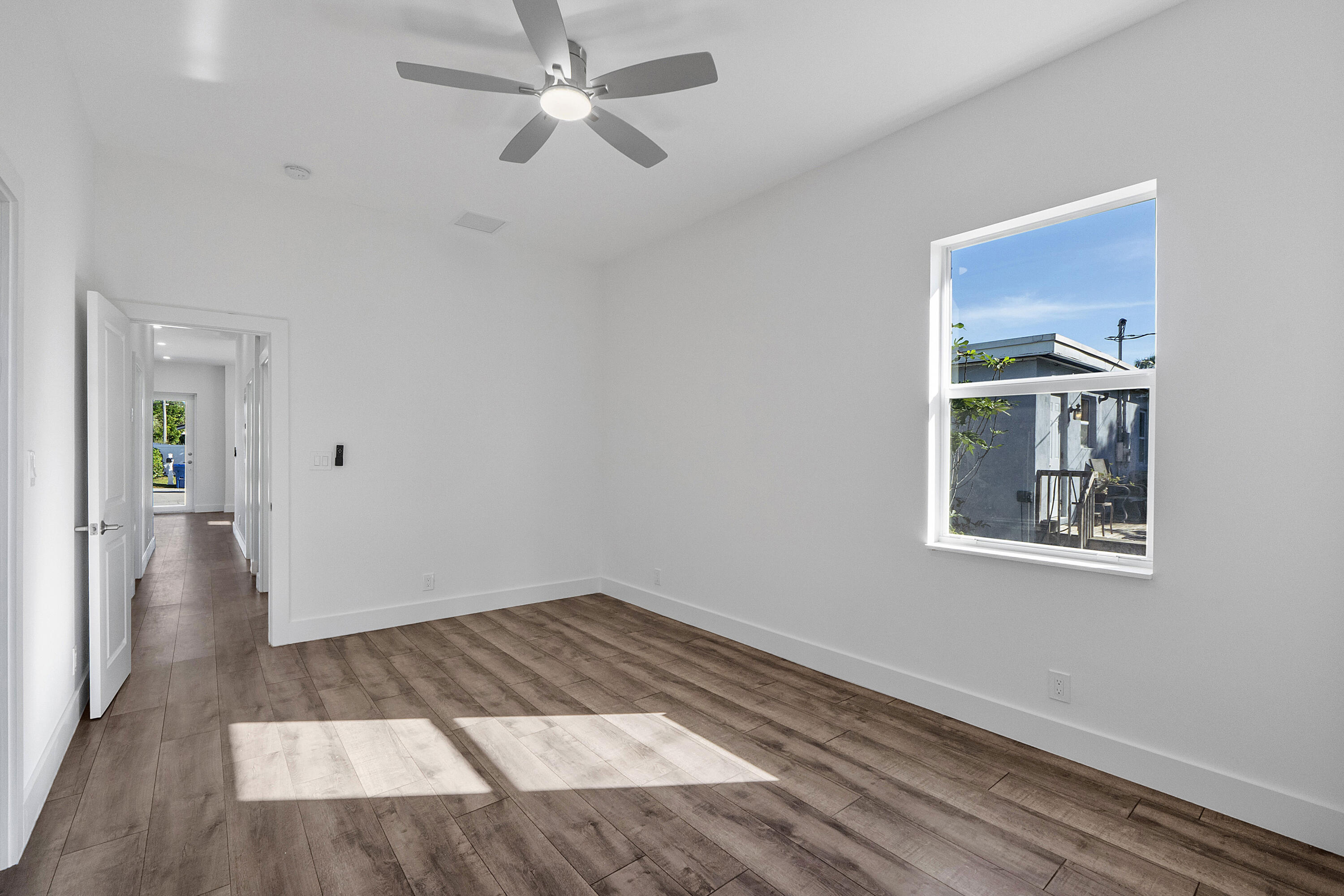 1573 West 16th Street Riviera Beach, FL 33404 - Photo 16 of 23 a view of an empty room with wooden floor and a window