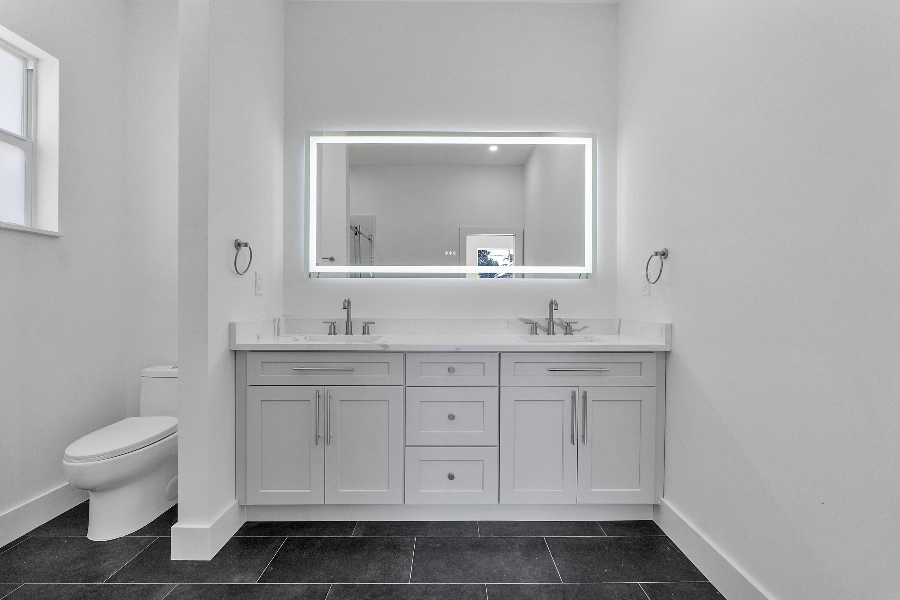 1573 West 16th Street Riviera Beach, FL 33404 - Photo 19 of 23 a bathroom with a sink a toilet and a mirror