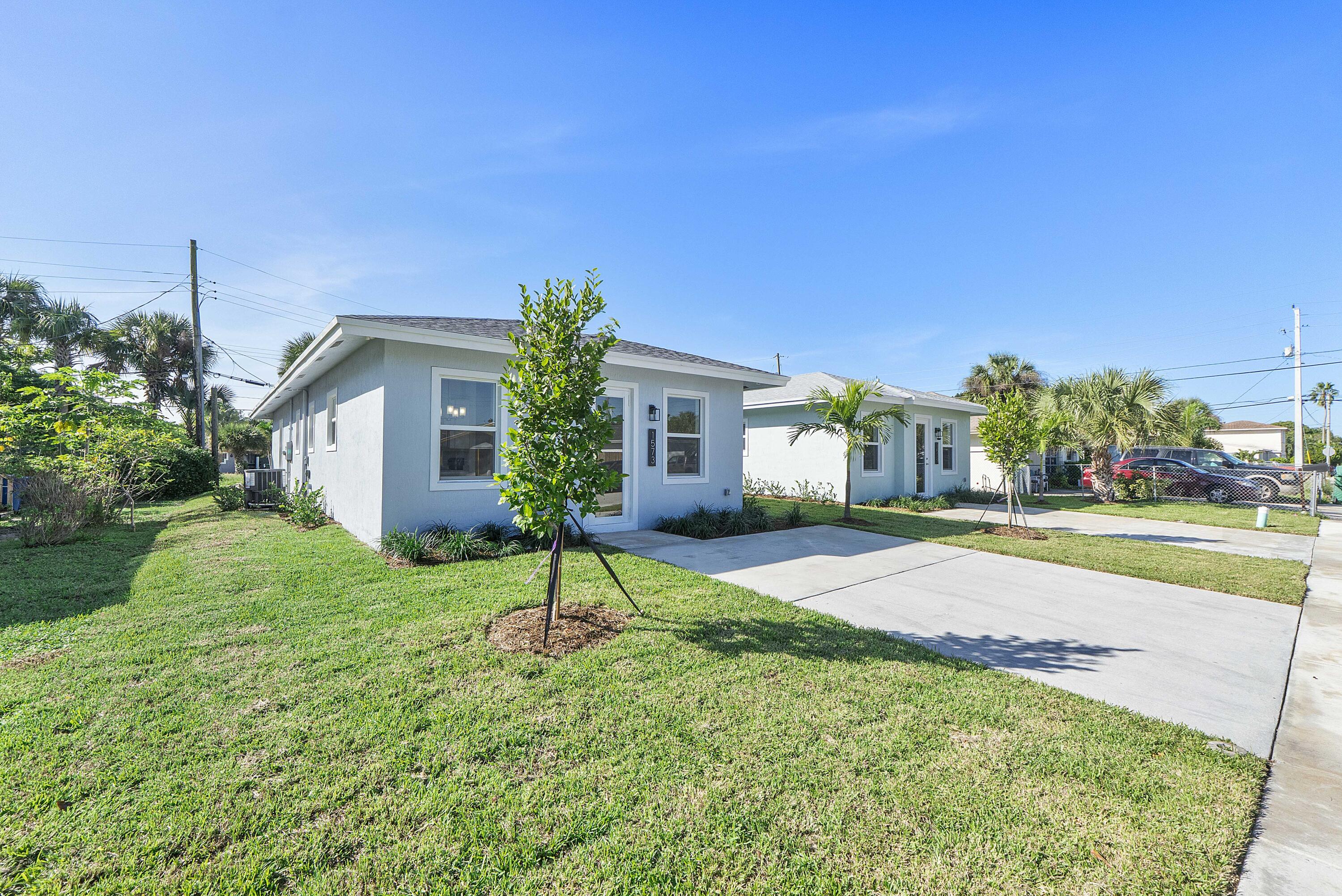 1573 West 16th Street Riviera Beach, FL 33404 - Photo 2 of 23 a house with garden in front of it
