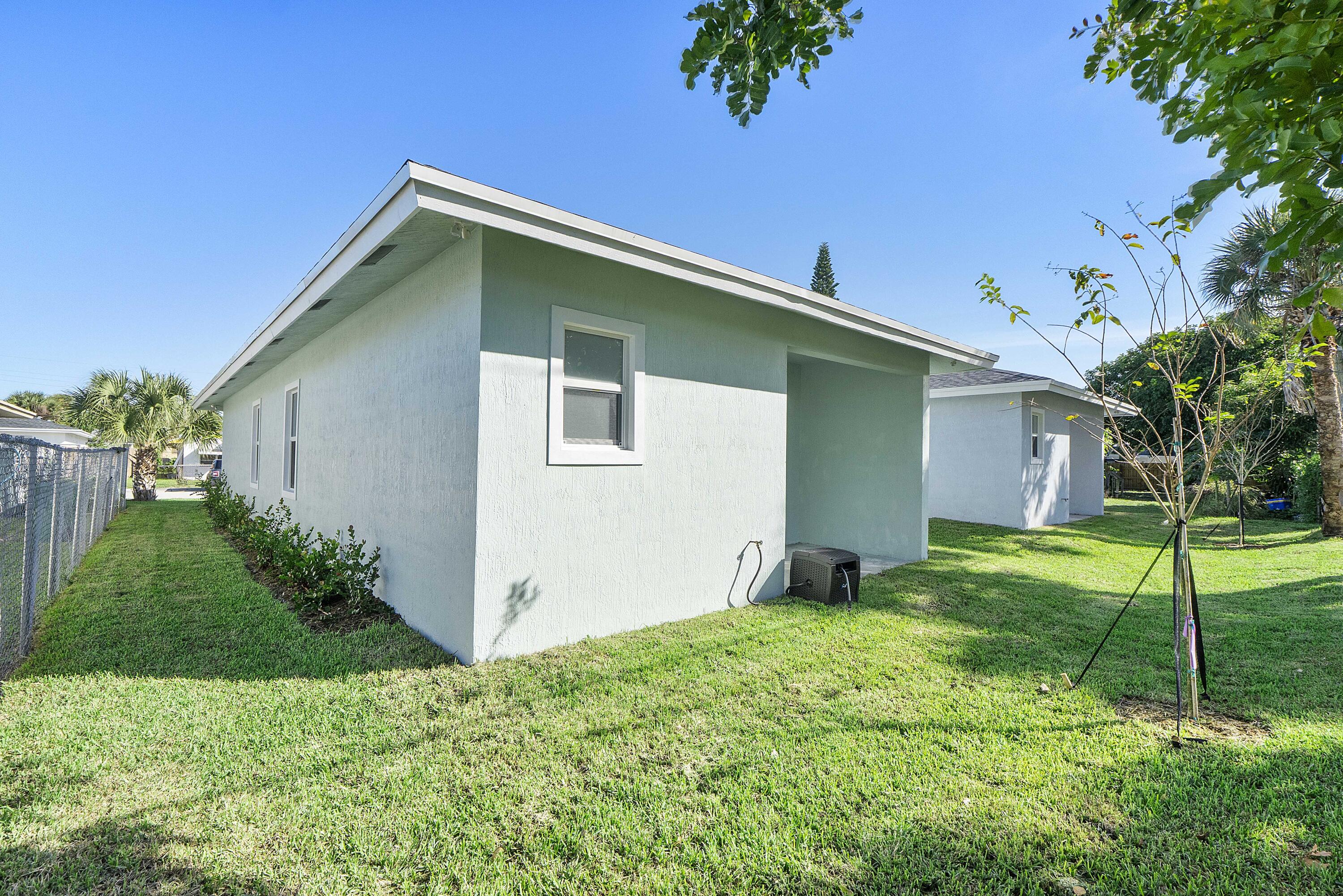 1573 West 16th Street Riviera Beach, FL 33404 - Photo 22 of 23 a backyard of a house with plants and garden