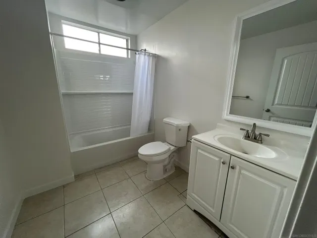 a bathroom with a granite countertop sink a toilet and a mirror