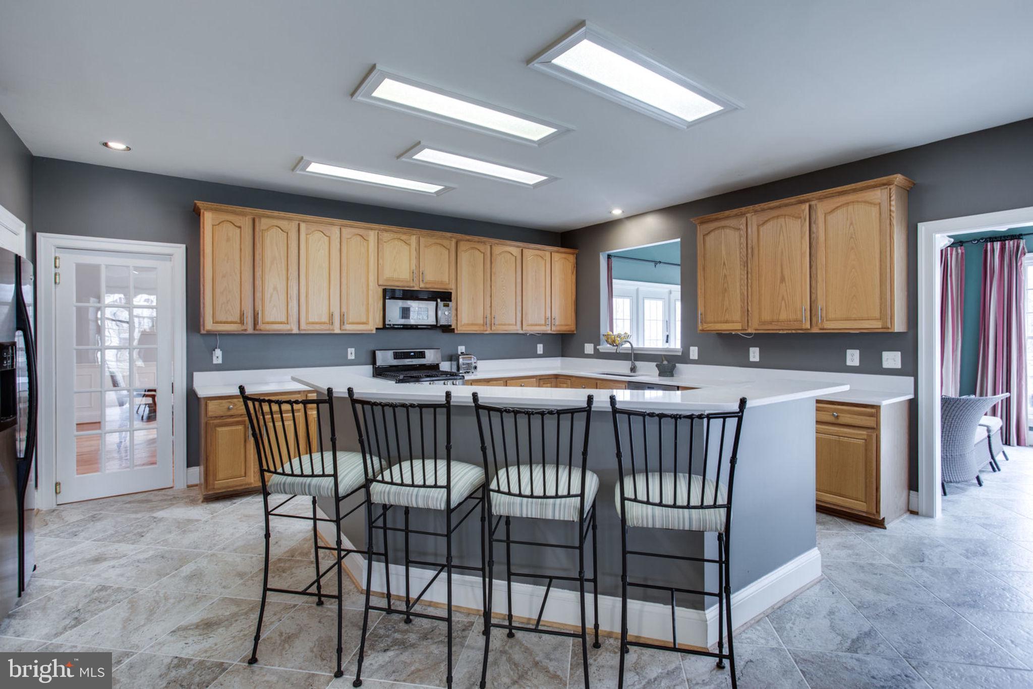 18621 Thundercloud Road Boyds, MD 20841 - Photo 19 of 83 a kitchen with stainless steel appliances granite countertop wooden cabinets a stove a sink dishwasher and a refrigerator