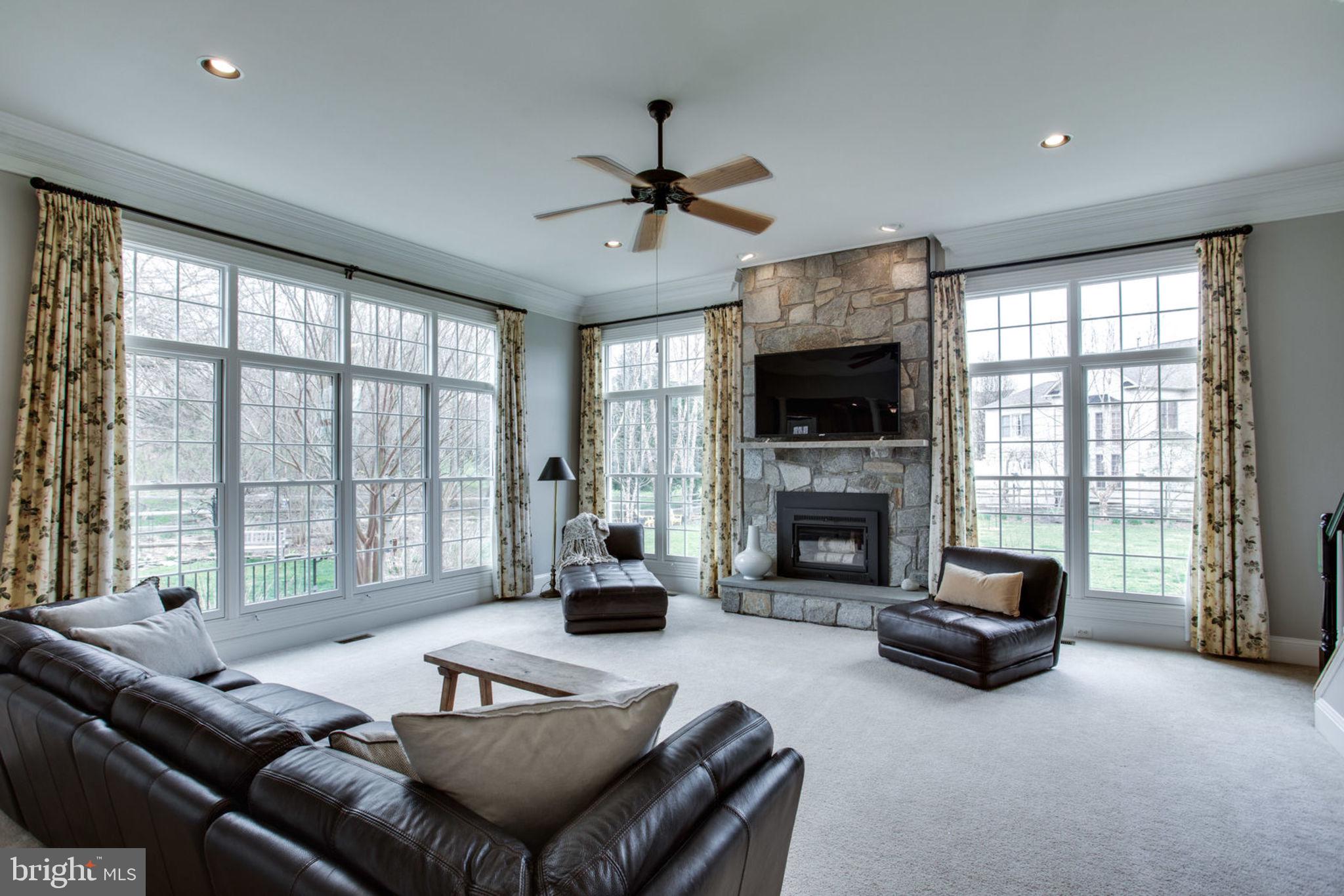 18621 Thundercloud Road Boyds, MD 20841 - Photo 28 of 83 a living room with furniture a fireplace and a large window with balcony view
