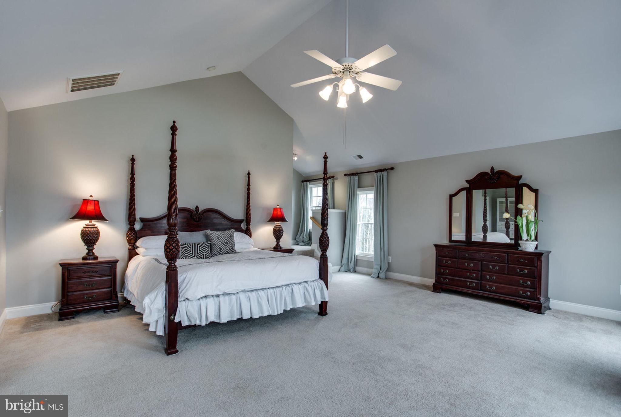 18621 Thundercloud Road Boyds, MD 20841 - Photo 42 of 83 a spacious bedroom with a bed and a chandelier