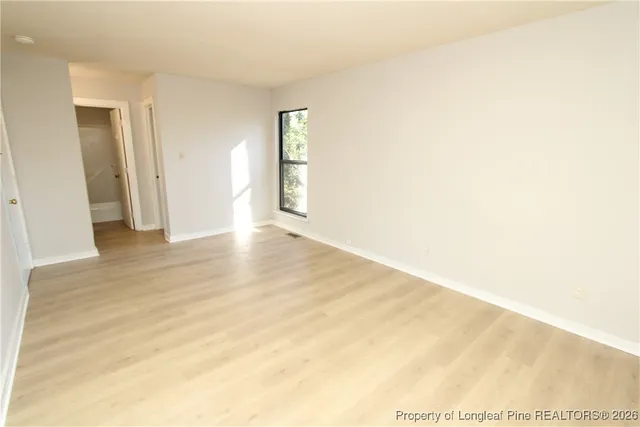 a view of an empty room with wooden floor