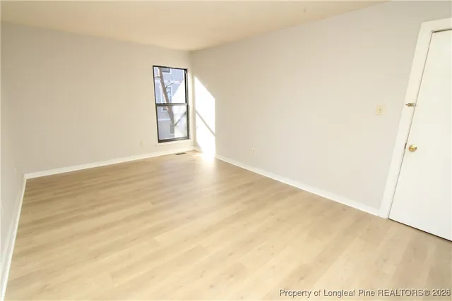 an empty room with windows and air conditioner