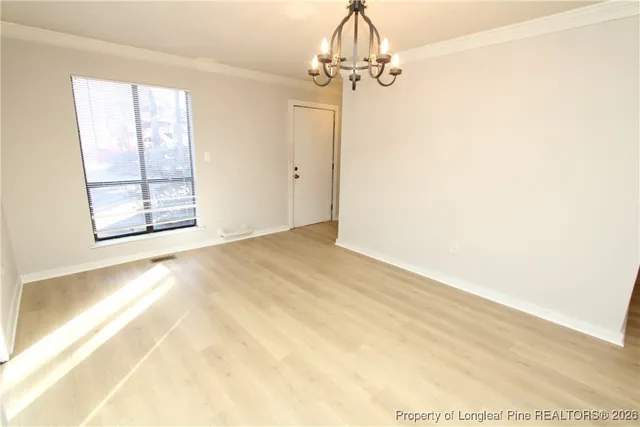 en empty room with windows and chandelier