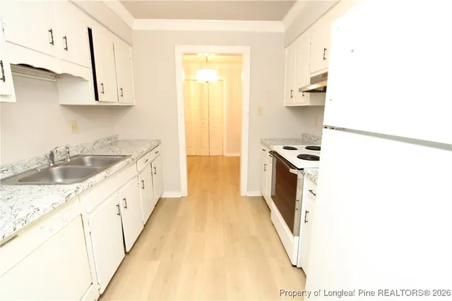 a kitchen with granite countertop a sink a stove and refrigerator