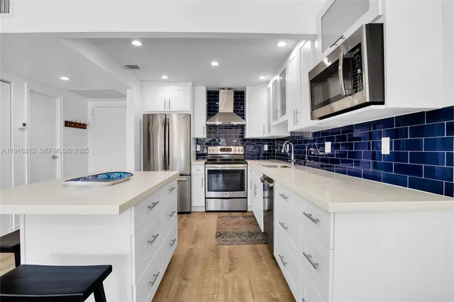 a kitchen with stainless steel appliances a stove sink microwave and refrigerator