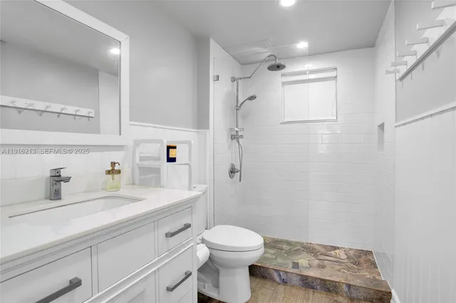 a bathroom with a sink toilet vanity and shower
