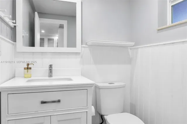 a bathroom with a sink a toilet and vanity