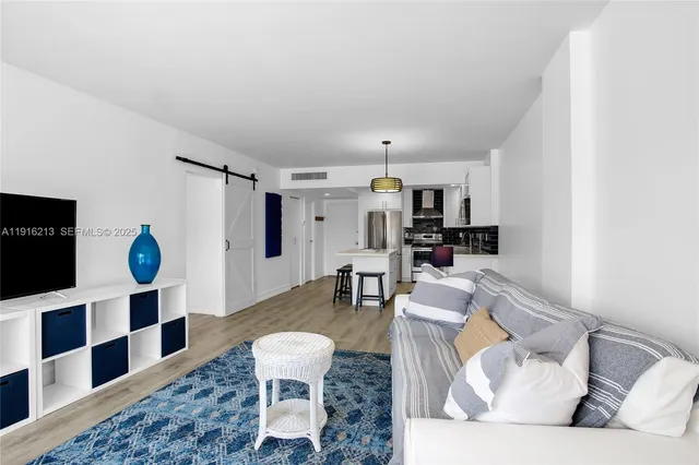 a living room with furniture and a dining table with wooden floor