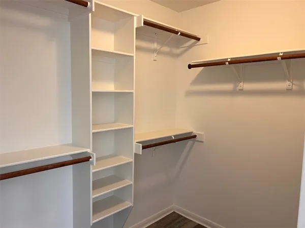 a view of walk in closet with empty racks