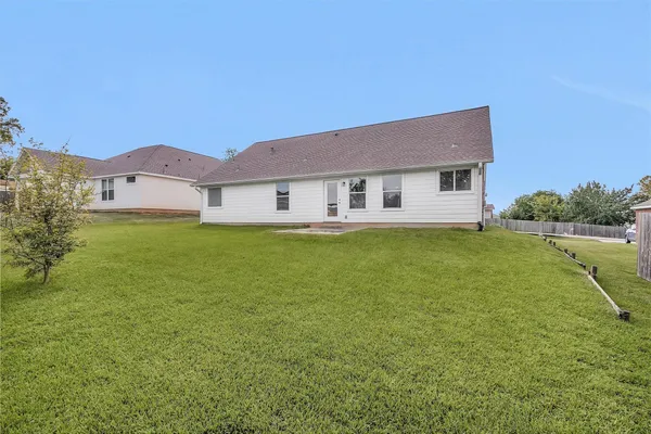 a view of a house with a big yard and a large tree
