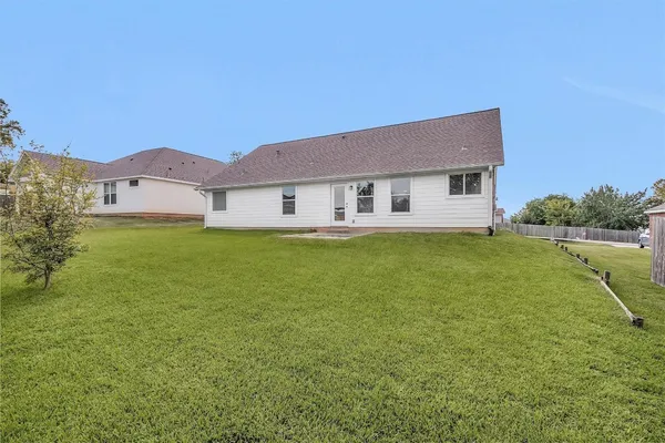 a view of a house with a big yard and a large tree