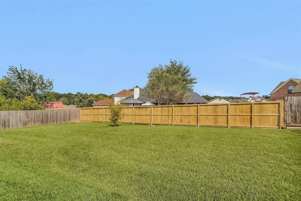 a view of a yard with wooden fence