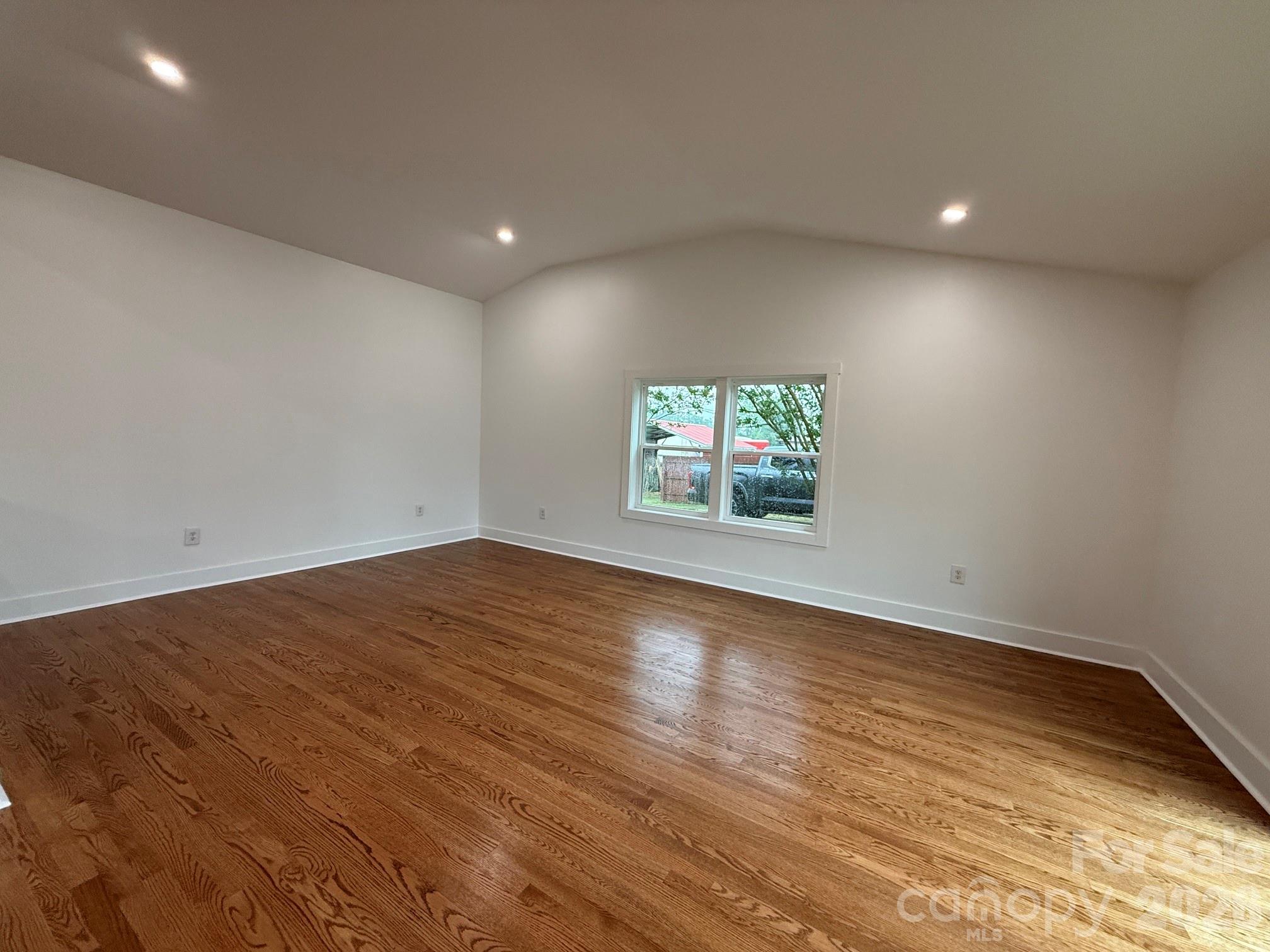 2677 Pax Hill Road Morganton, NC 28655 - Photo 7 of 15 an empty room with wooden floor and windows