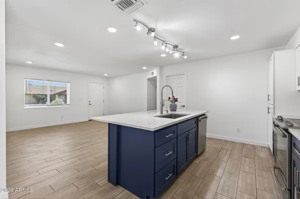 a kitchen with stainless steel appliances kitchen island granite countertop a stove a microwave and a sink