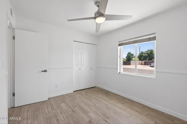 an empty room with a window and a ceiling fan