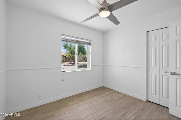 an empty room with a ceiling fan and wooden floor