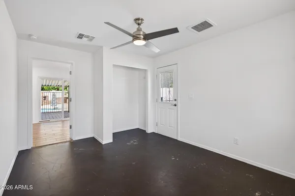 an empty room with a window and a ceiling fan
