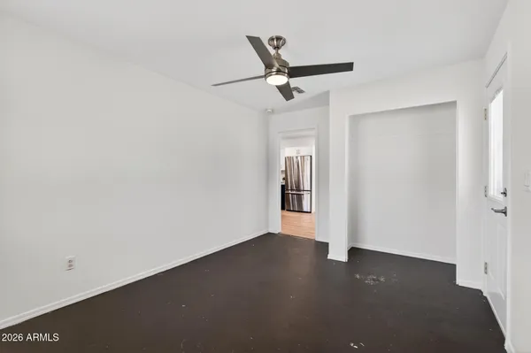 an empty room with wooden floor a ceiling fan and a window