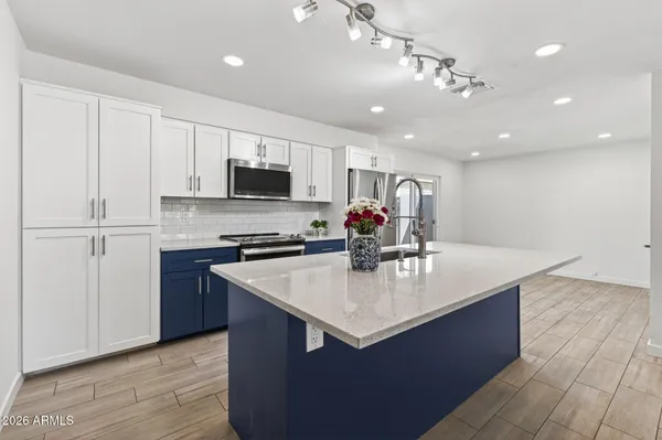 a large kitchen with stainless steel appliances granite countertop a stove a sink and a refrigerator