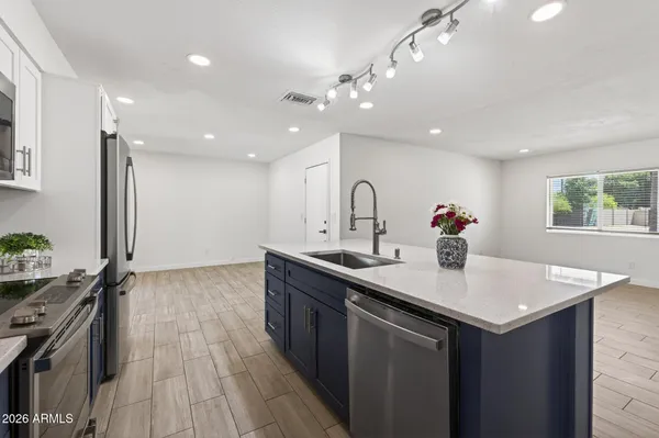 a kitchen with stainless steel appliances granite countertop a sink a stove and a refrigerator