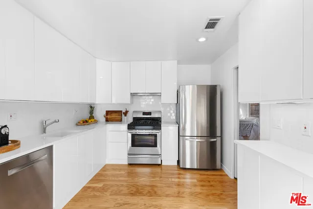 a kitchen with wooden cabinets and stainless steel appliances