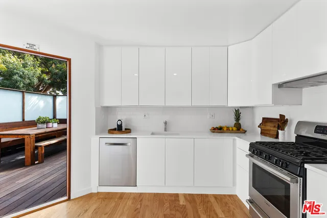 a kitchen with stainless steel appliances granite countertop a stove a sink and a white cabinets