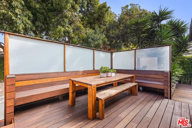a backyard of a house with wooden floor and outdoor seating