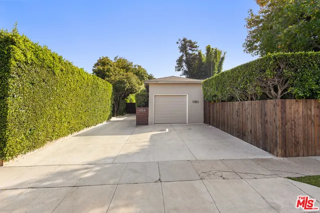 a view of a house with a yard and potted plants