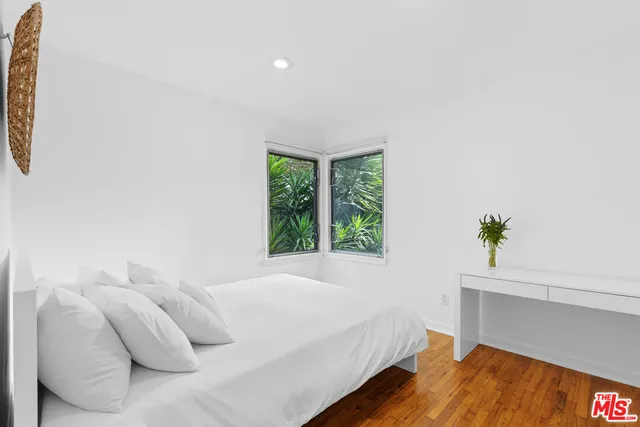 a bedroom with a bed and a potted plant