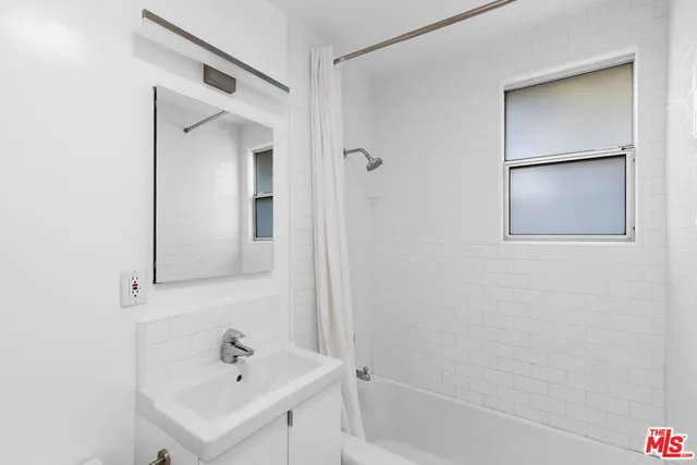 a bathroom with a sink a shower and a mirror