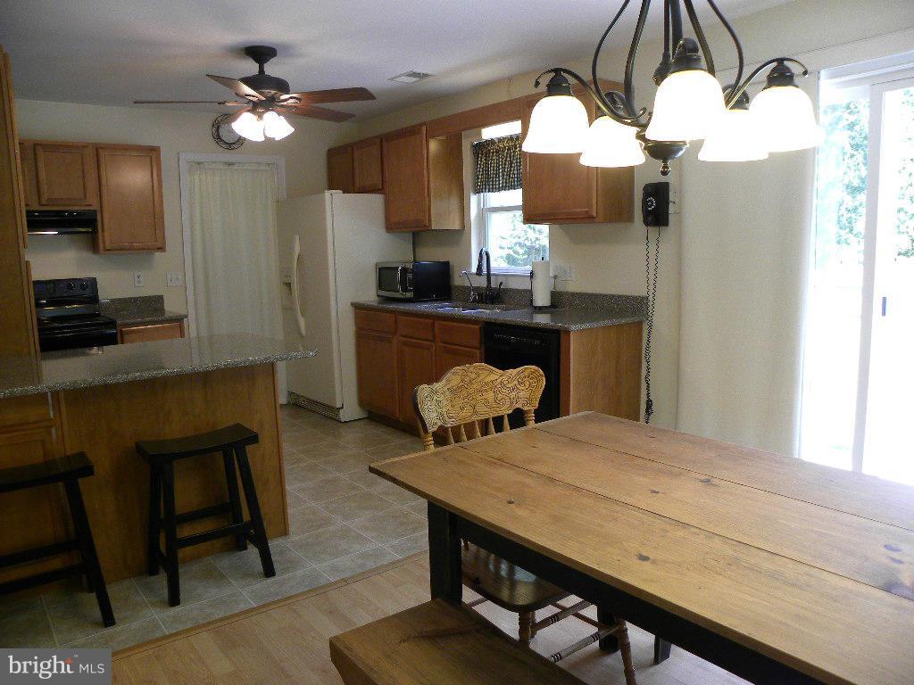 2414 Busic Church Road Marydel, MD 21649 - Photo 11 of 30 a kitchen with a table chairs and flat screen tv