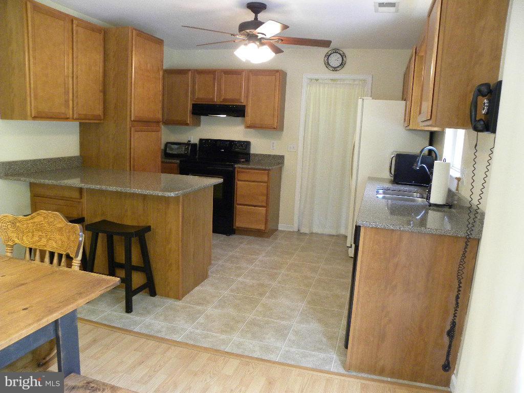 2414 Busic Church Road Marydel, MD 21649 - Photo 12 of 30 a kitchen with kitchen island granite countertop a refrigerator a stove top oven a sink and dishwasher