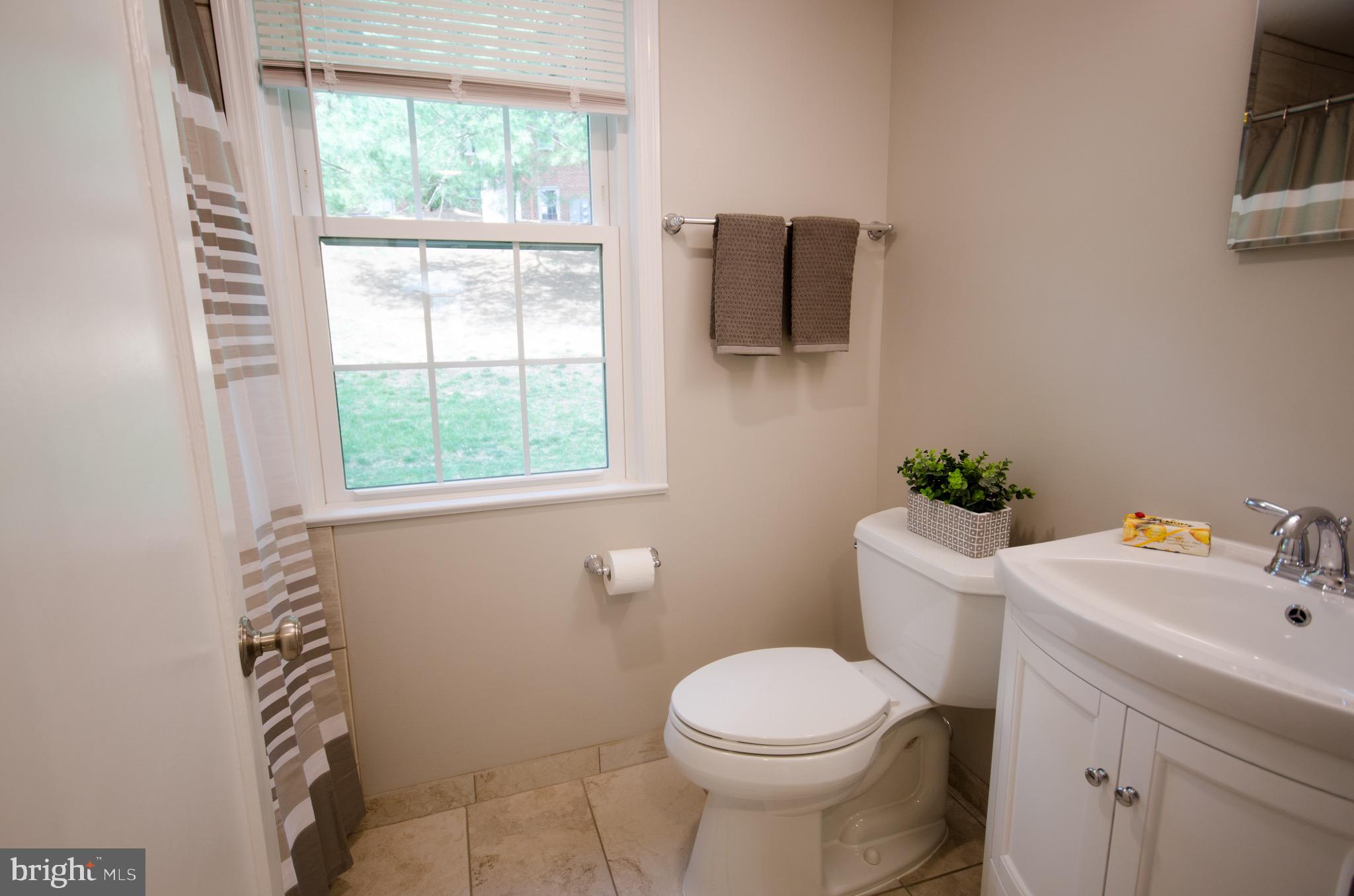 8201 Grubb Road, Unit 101 Silver Spring, MD 20910 - Photo 13 of 31 a bathroom with a sink toilet and window