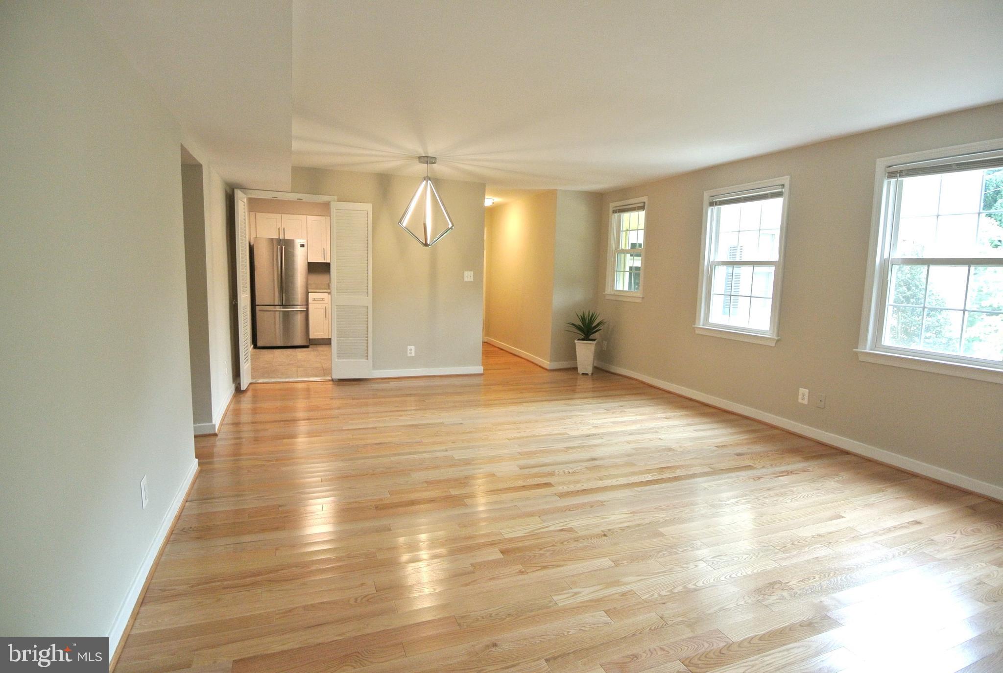 8201 Grubb Road, Unit 101 Silver Spring, MD 20910 - Photo 7 of 31 an empty room with wooden floor and windows