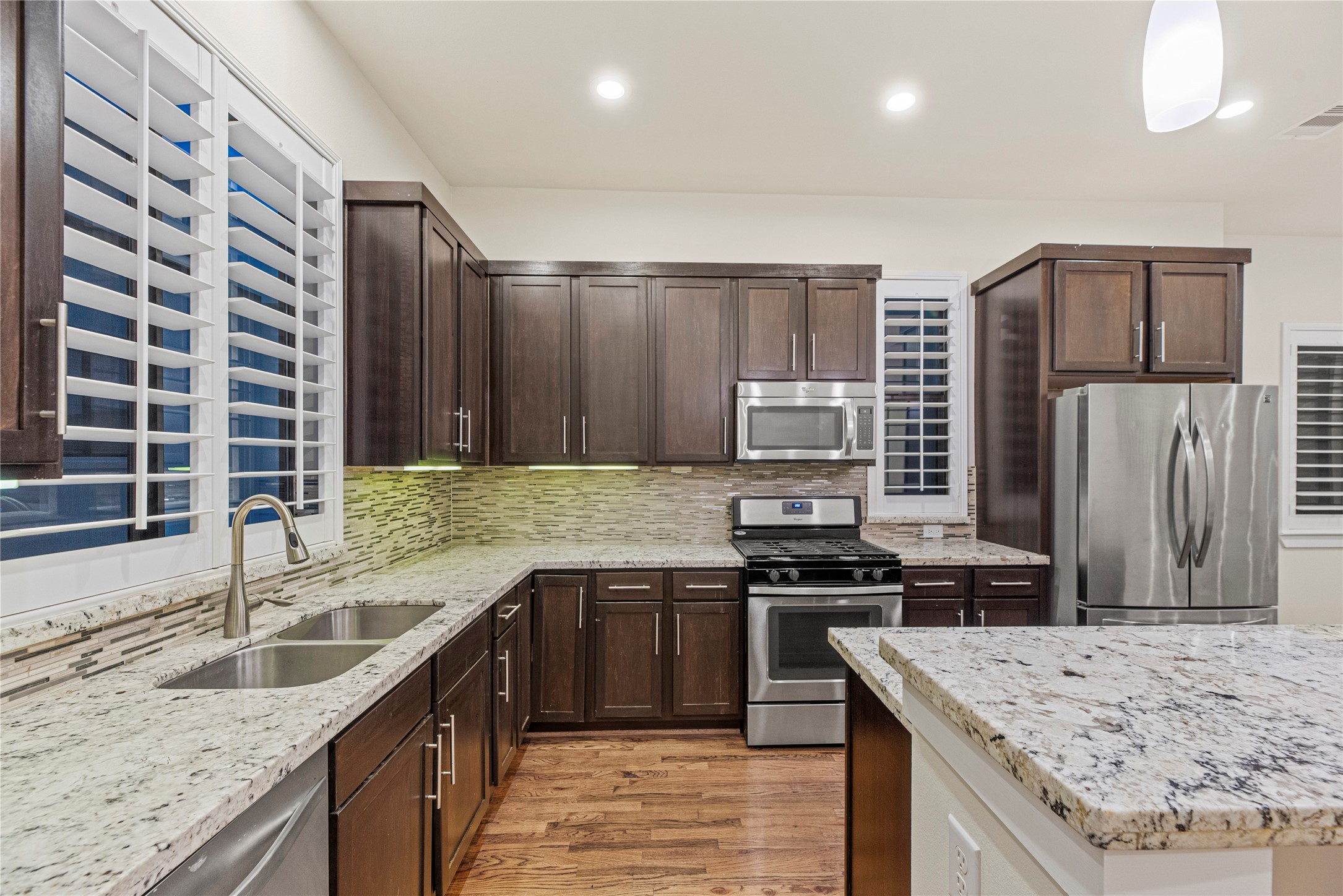 2513 B Garrow Street Houston, TX 77003 - Photo 11 of 29 Granite countertops, glass tile backsplash, under cabinet lighting, stainless steel appliances, gas range and pantry.