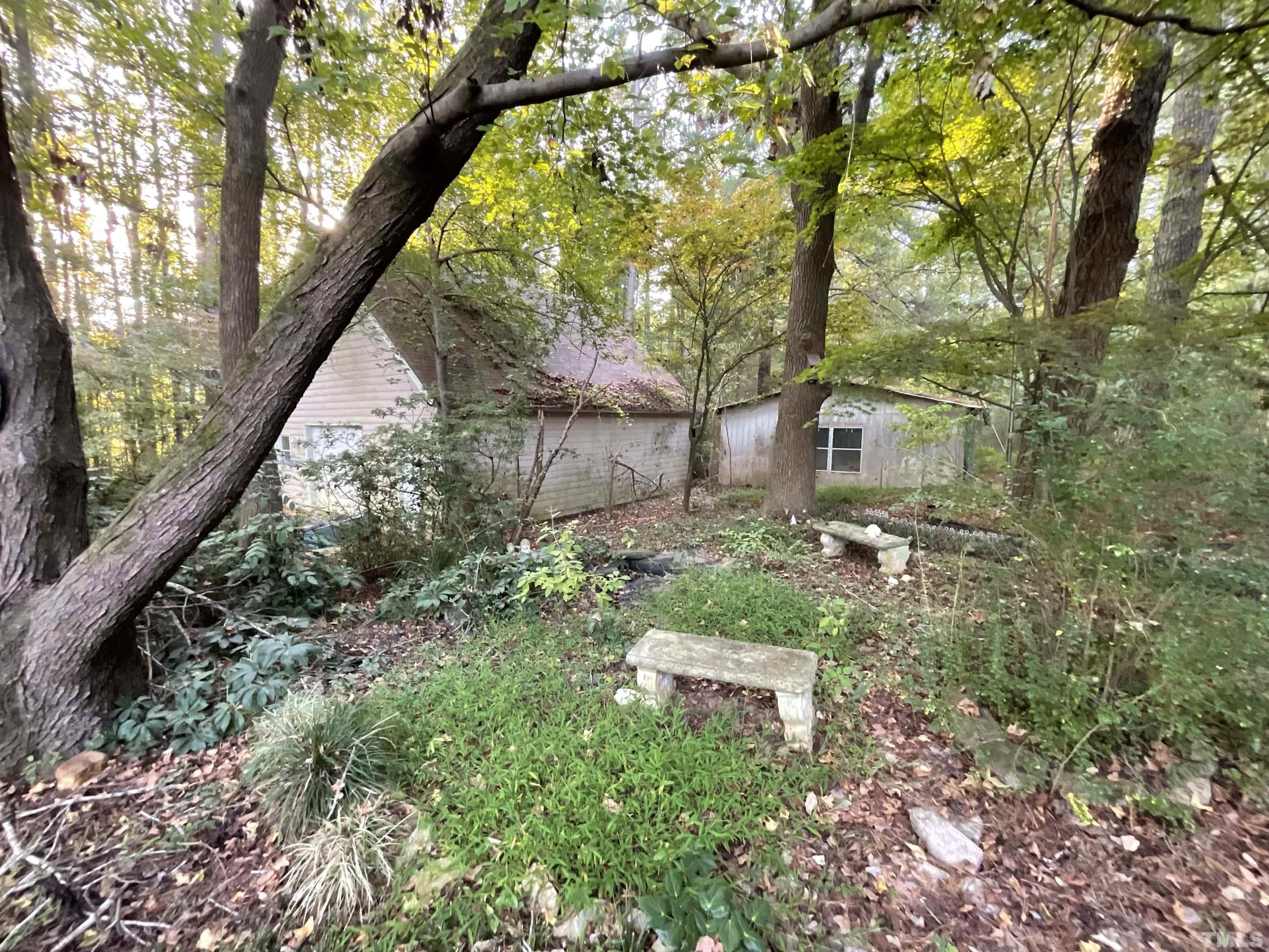 8229 Holly Springs Road Raleigh, NC 27606 - Photo 15 of 24 a backyard of a house with outdoor seating and trees