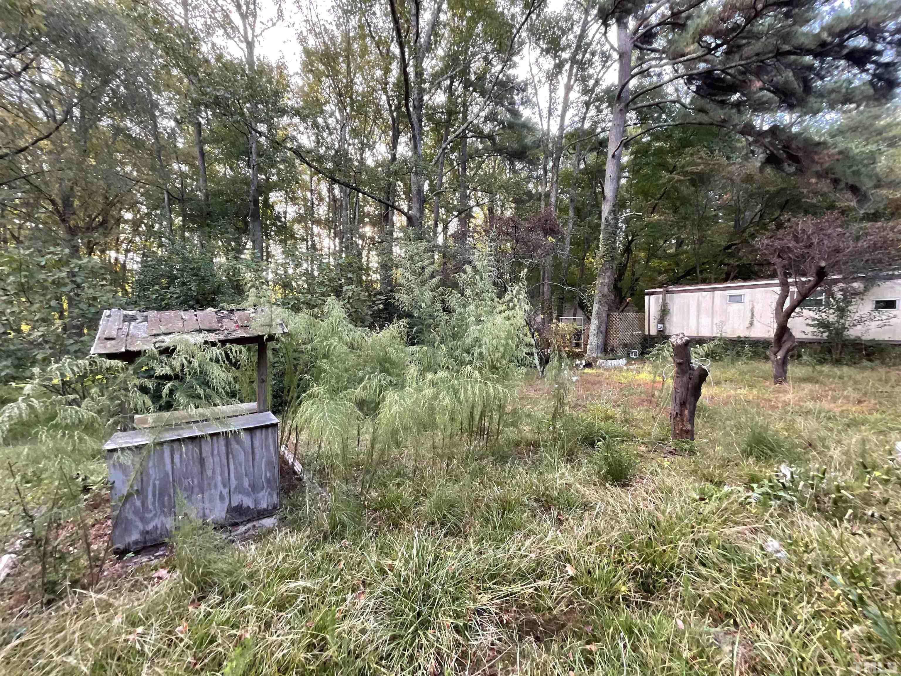 8229 Holly Springs Road Raleigh, NC 27606 - Photo 3 of 24 a wooden fence with some trees in the background