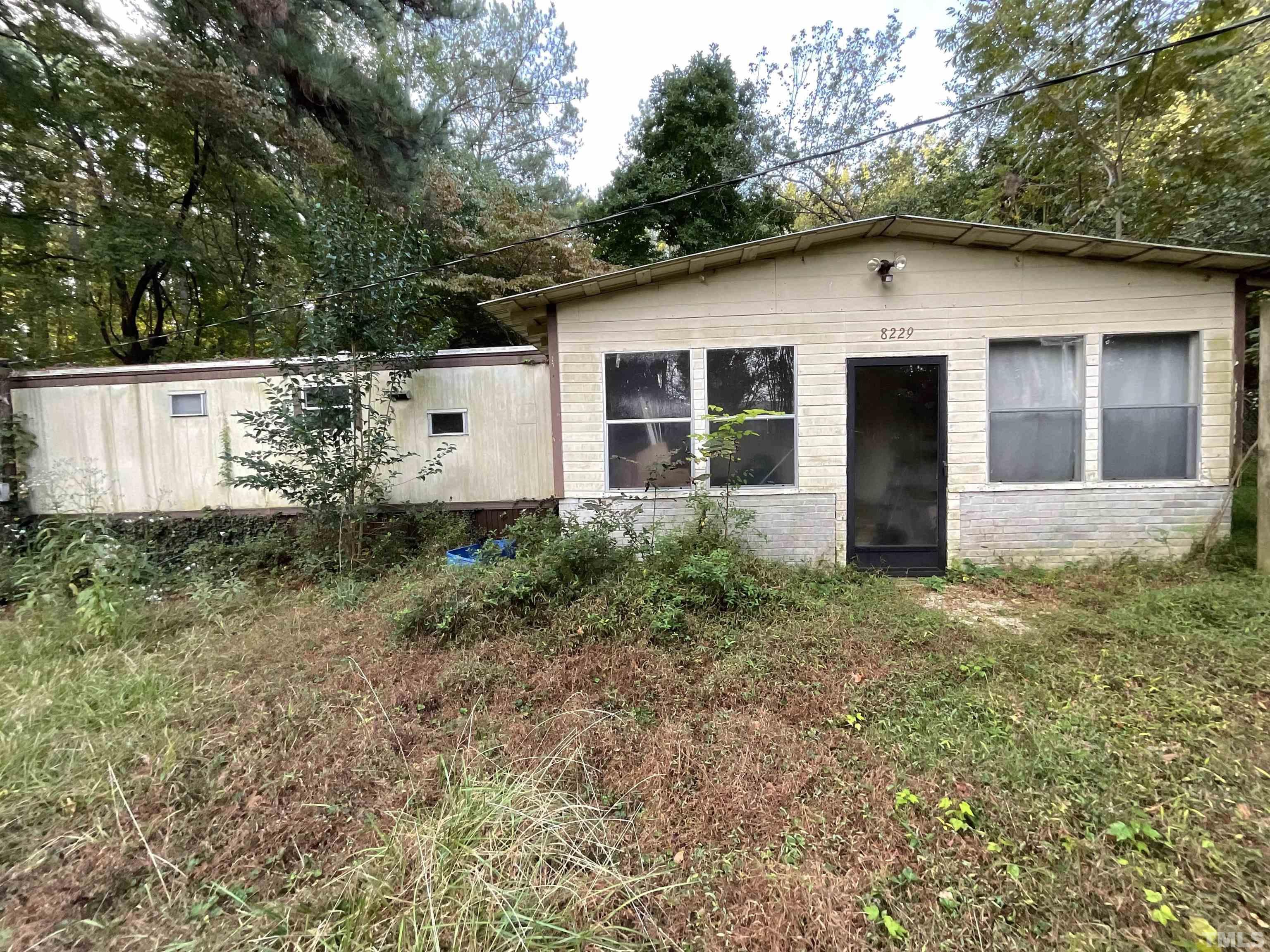 8229 Holly Springs Road Raleigh, NC 27606 - Photo 4 of 24 a house with trees in front of it