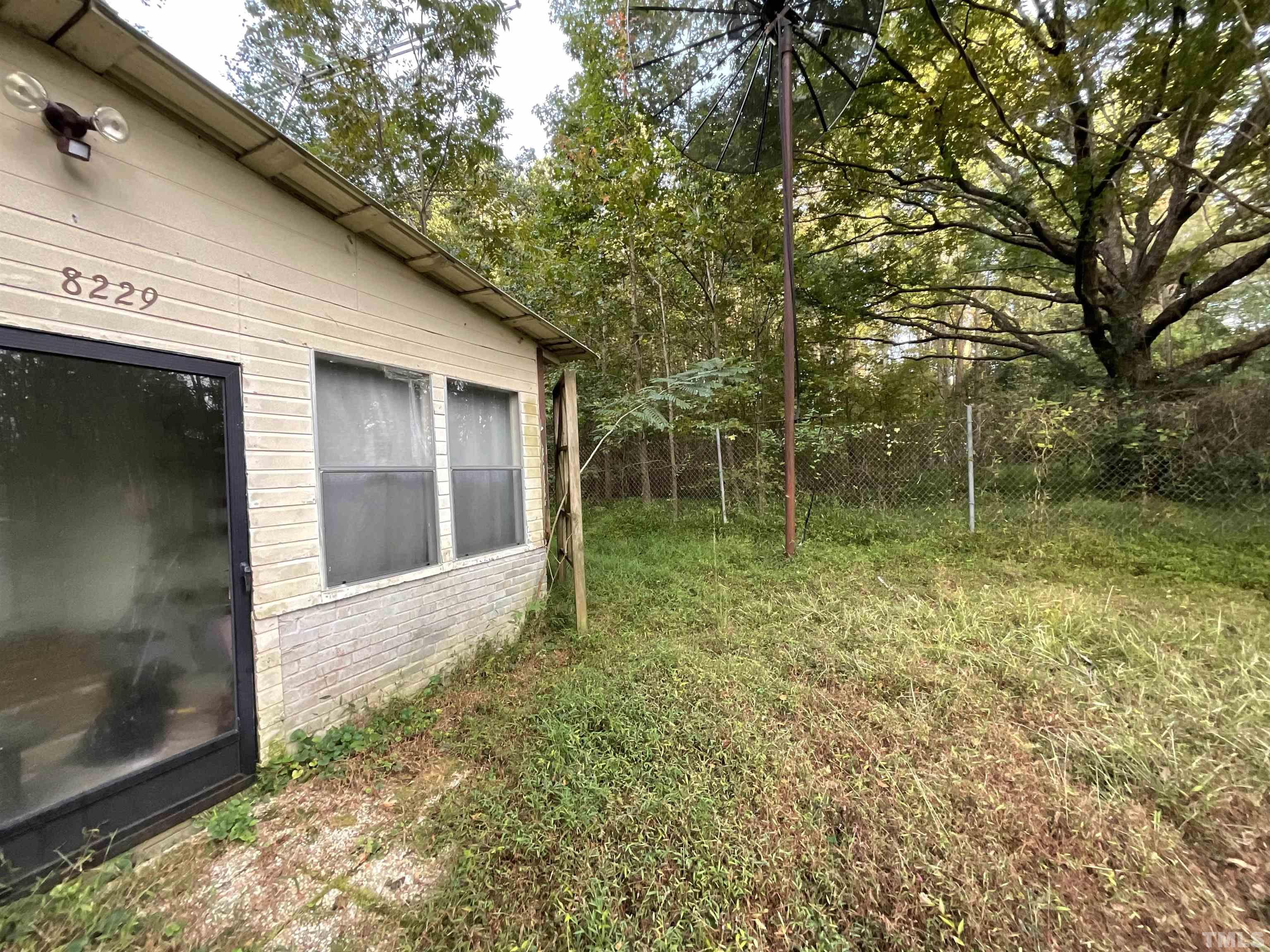 8229 Holly Springs Road Raleigh, NC 27606 - Photo 7 of 24 a backyard of a house with lots of green space
